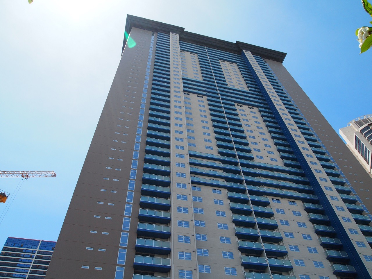 A tall building with a crane in the background.